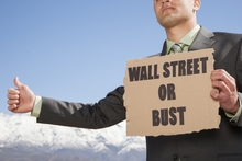 Man holding sign Wall Street or Bust